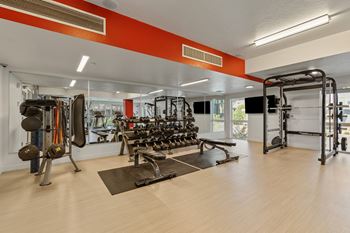 A gym with a variety of equipment including weights and machines.
